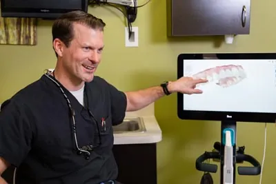 Dr. Cutting showing how a dental crown can help restore a patient's smile